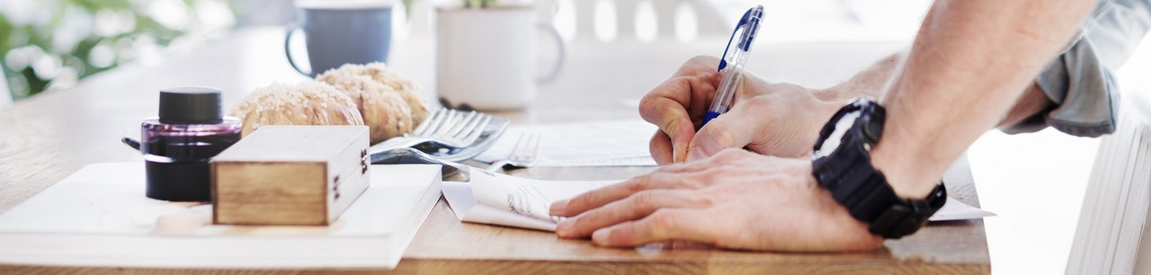 Homme qui rédige des notes, définitions sur un bureau